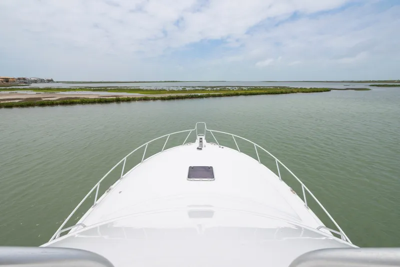 Slide: The Image of Bow view of 2005 Cabo 40 Flybridge yacht on calm waters. - 11