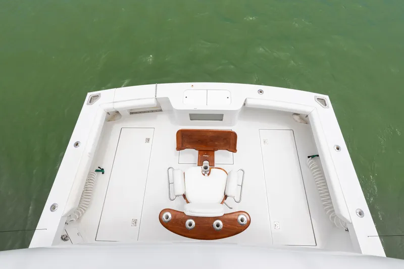 Slide: The Image of 2005 Cabo 40 Flybridge cockpit with fishing chair, overlooking green water. - 12