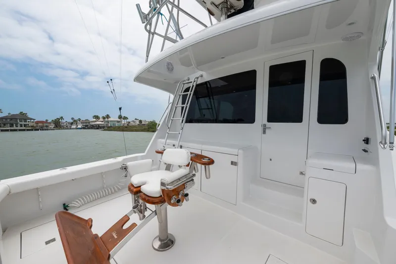 Slide: The Image of 2005 Cabo 40 Flybridge yacht deck with fishing chair and ladder, overlooking waterfront homes. - 14