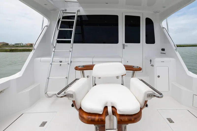Slide: The Image of 2005 Cabo 40 Flybridge yacht cockpit with ladder and seating, overlooking water. - 15