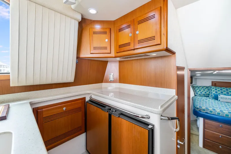 Slide: The Image of 2005 Cabo 40 Flybridge interior with wooden cabinets and compact kitchen area. - 23
