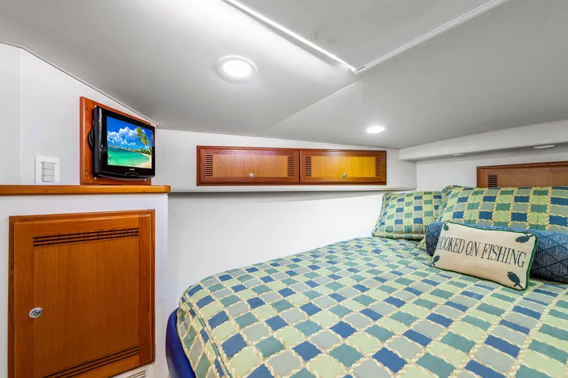 Slide: The Image of Cozy cabin interior of 2005 Cabo 40 Flybridge with bed, TV, and fishing-themed decor. - 26