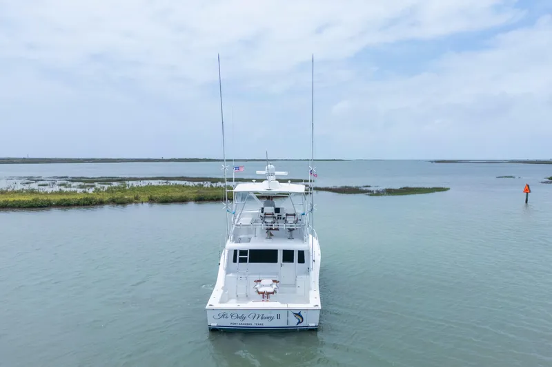 Slide: The Image of 2005 Cabo 40 Flybridge yacht on calm waters, rear view, clear sky. - 3