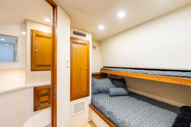 Slide: The Image of 2005 Cabo 40 Flybridge cabin with bunk beds and wooden cabinetry. - 30