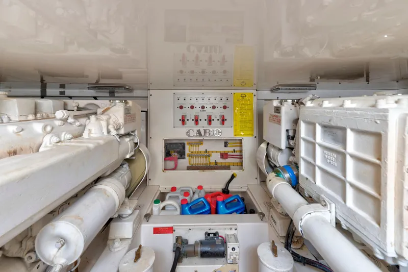 Slide: The Image of Engine room of a 2005 Cabo 40 Flybridge boat, featuring machinery and maintenance supplies. - 32