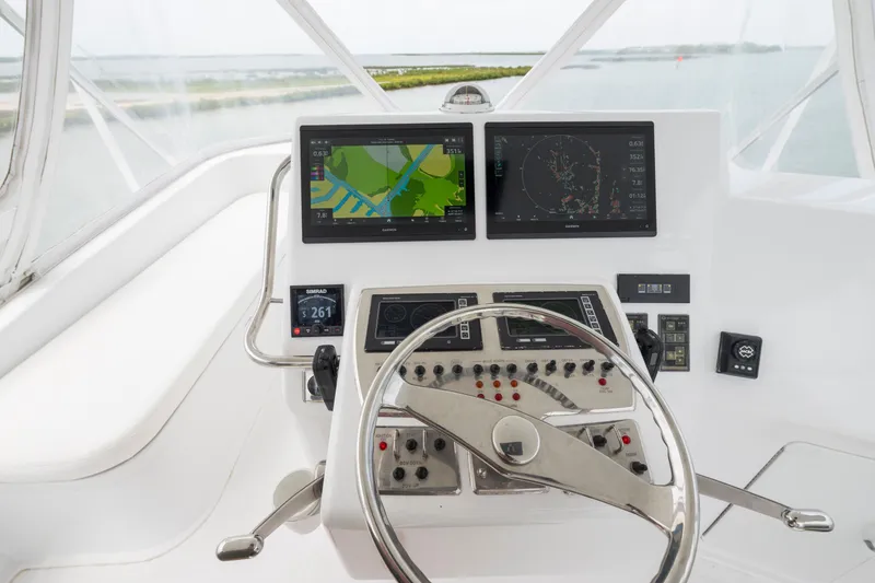 Slide: The Image of Helm of 2005 Cabo 40 Flybridge with navigation screens and controls. - 6