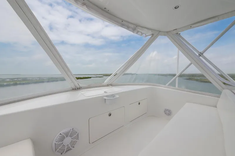 Slide: The Image of Interior view of 2005 Cabo 40 Flybridge yacht with panoramic windows and serene water view. - 7