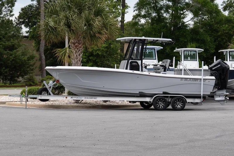 The Image of 2026 Blazer Bay Makaira 2600 boat on trailer, parked outdoors near palm trees. - 1