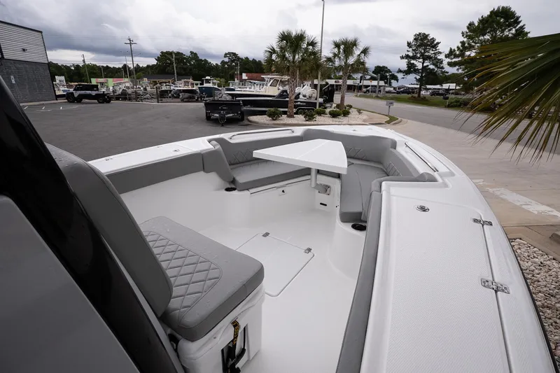 Slide: The Image of 2026 Blazer Bay Makaira 2600 boat interior with seating and table, parked outdoors. - 17