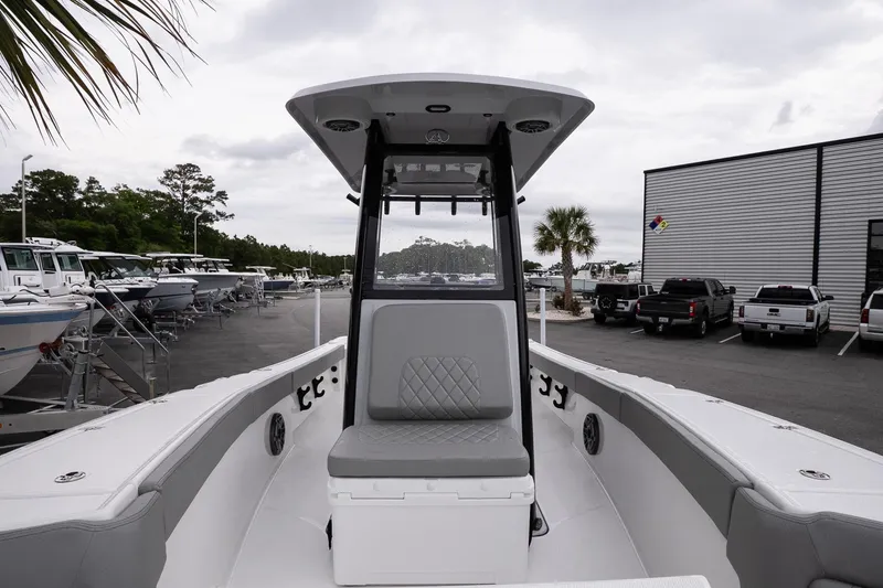 Slide: The Image of 2026 Blazer Bay Makaira 2600 boat interior at a dealership, showcasing seating and console. - 19