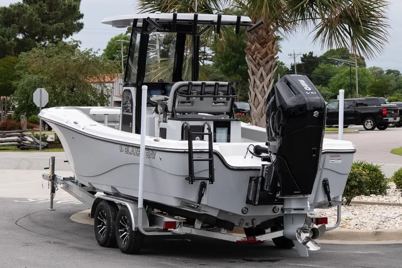 Slide: The Image of 2026 Blazer Bay Makaira 2600 boat on trailer, parked near palm tree. - 4