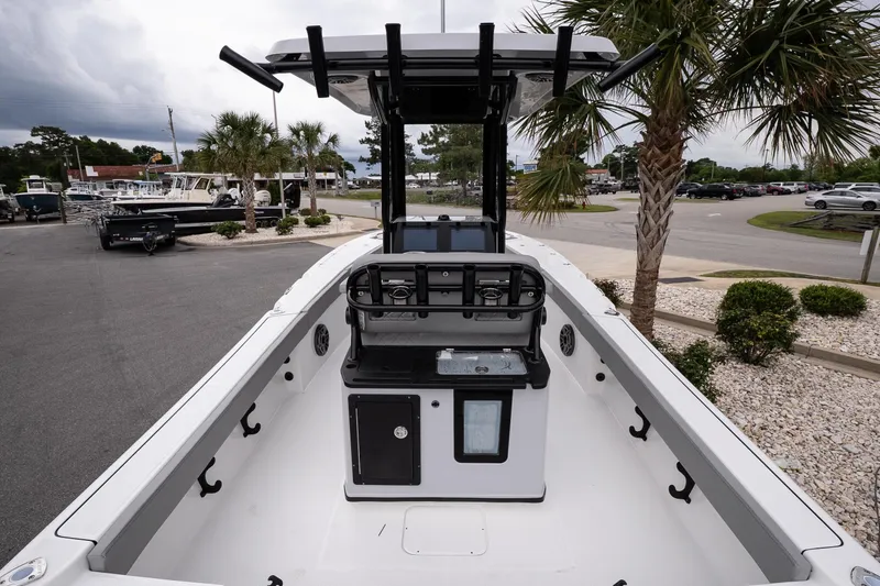 Slide: The Image of 2026 Blazer Bay Makaira 2600 boat interior with console, parked near palm trees. - 7