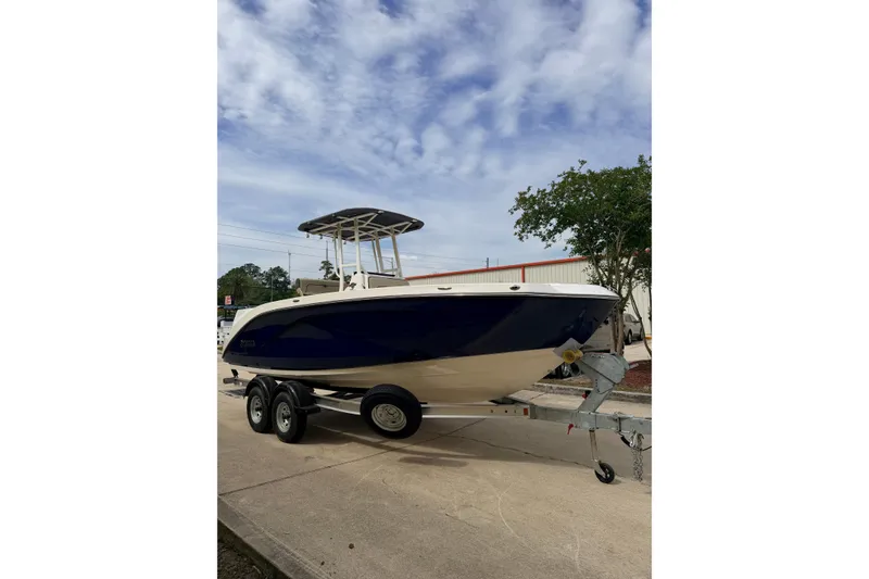 The Image of 2026 Yamaha Boats 222 FSH Sport on trailer, parked outdoors under cloudy sky. - 0