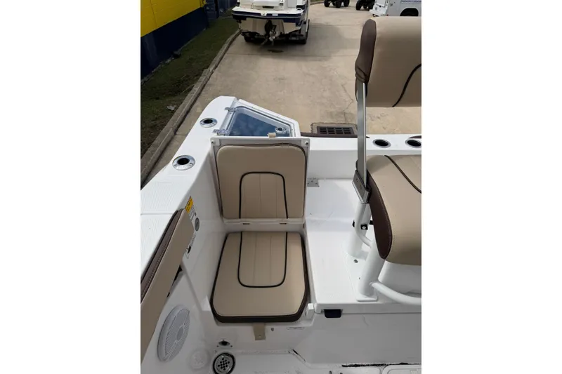 Slide: The Image of 2026 Yamaha Boats 222 FSH Sport interior seating with beige cushions and cup holders. - 17