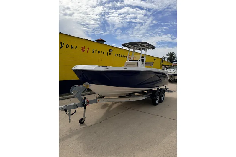 Slide: The Image of 2026 Yamaha Boats 222 FSH Sport on trailer, parked outside a yellow building. - 2