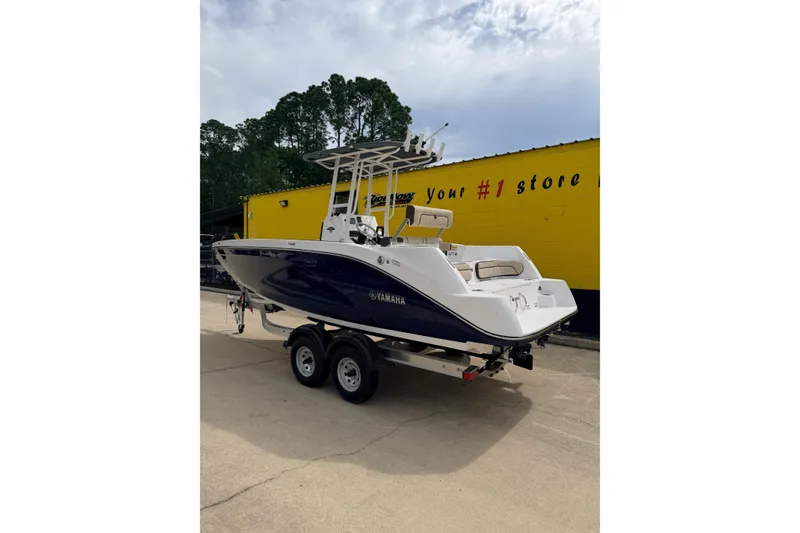 Slide: The Image of 2026 Yamaha Boats 222 FSH Sport on trailer, parked outside a yellow building. - 3
