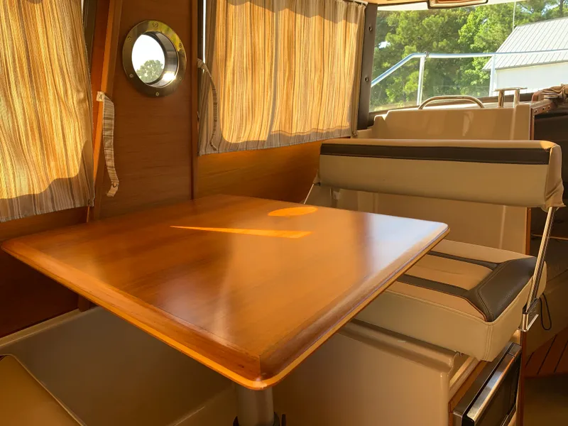 Slide: The Image of Interior of 2018 Ranger Tugs R-23 with wooden table and seating. - 11
