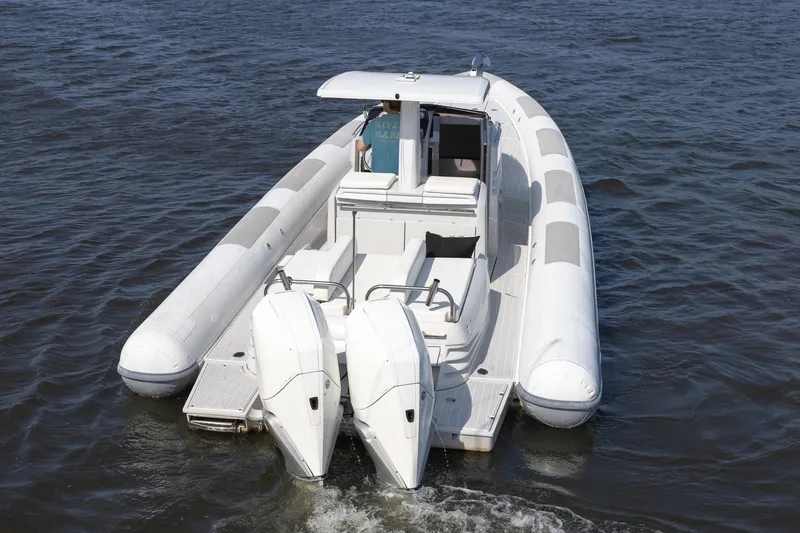 Slide: The Image of 2013 Zeta Elle 34 Custom boat on water, featuring dual engines and sleek design. - 7