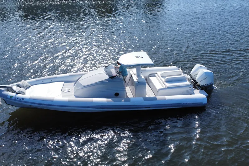 The Image of 2013 Zeta Elle 34 Custom boat on shimmering water, featuring sleek design and powerful outboard motor. - 0