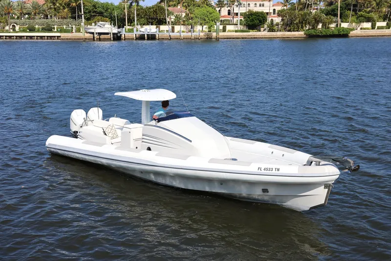 Slide: The Image of 2013 Zeta Elle 34 Custom boat on calm water near a lush shoreline. - 10
