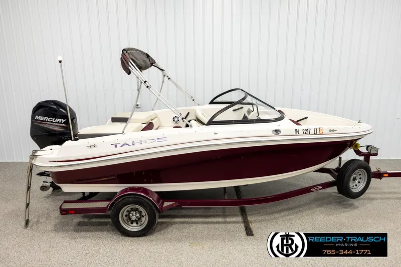 The Image of 2016 Tahoe 450 TS boat with Mercury engine on trailer, displayed indoors. - 1