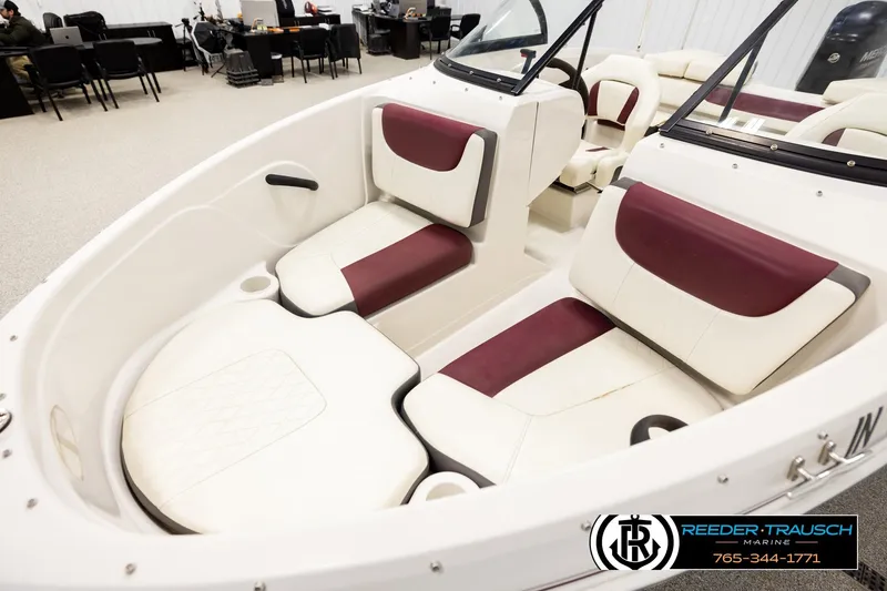 Slide: The Image of 2016 Tahoe 450 TS boat interior with white and maroon seating in showroom. - 10