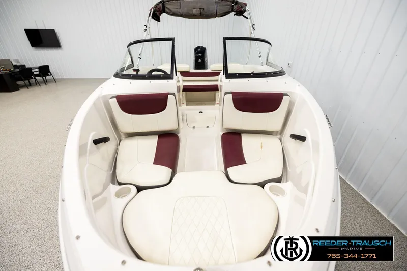 Slide: The Image of 2016 Tahoe 450 TS boat interior with white and maroon seating in showroom. - 16