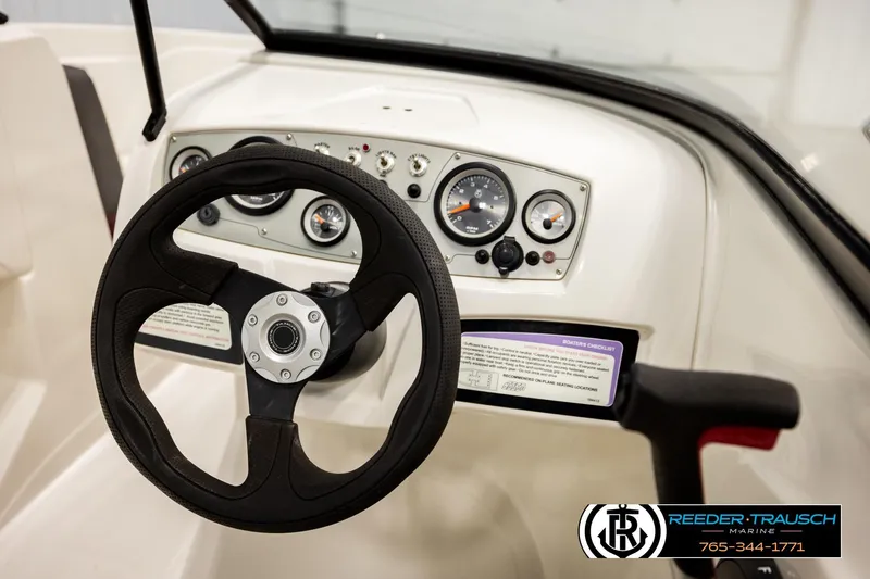 Slide: The Image of Steering wheel and dashboard of 2016 Tahoe 450 TS boat, featuring gauges and controls. - 26
