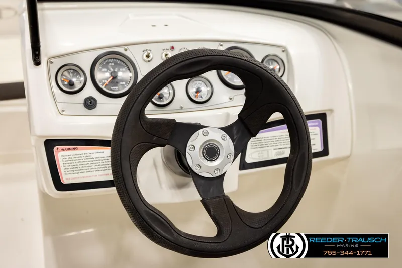 Slide: The Image of Steering wheel and dashboard of 2016 Tahoe 450 TS boat, featuring gauges and controls. - 27