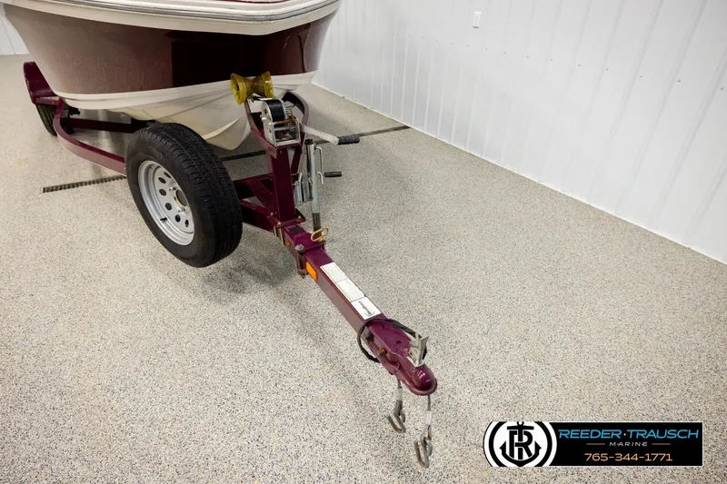 Slide: The Image of 2016 Tahoe 450 TS boat trailer in a showroom with contact details. - 41