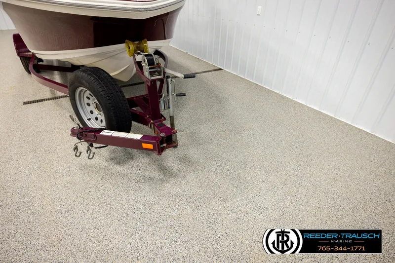 Slide: The Image of 2016 Tahoe 450 TS boat on trailer in showroom with Reeder-Trausch Marine logo. - 42