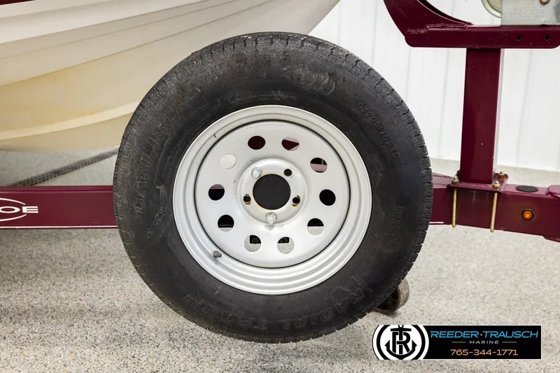 Slide: The Image of Trailer wheel of a 2016 Tahoe 450 TS boat on a maroon frame. - 44