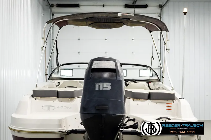 Slide: The Image of 2016 Tahoe 450 TS boat with outboard motor in a garage setting. - 7