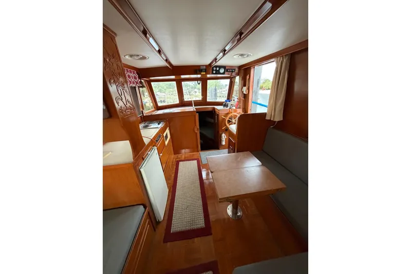 Slide: The Image of Interior of 1988 Marine Trader 34 Double Cabin with wood finish and seating area. - 11