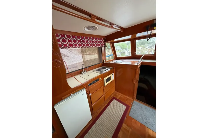 Slide: The Image of 1988 Marine Trader 34 Double Cabin interior with kitchenette and wood finish. - 12