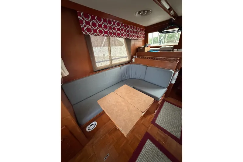Slide: The Image of 1988 Marine Trader 34 Double Cabin interior with cozy seating and wooden accents. - 13
