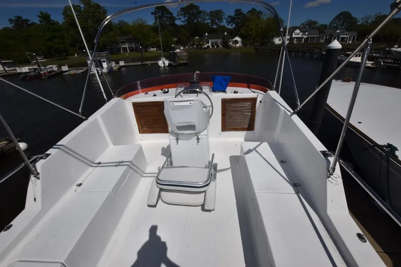Slide: The Image of 1988 Marine Trader 34 Double Cabin boat deck with seating and steering wheel, docked at marina. - 14