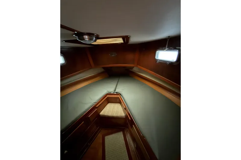Slide: The Image of Interior cabin of 1988 Marine Trader 34 Double Cabin with wood paneling and bedding. - 4
