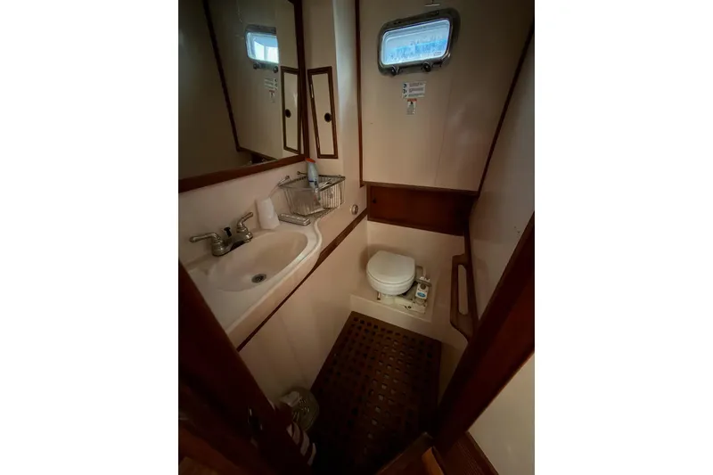 Slide: The Image of 1988 Marine Trader 34 Double Cabin bathroom with sink, toilet, and porthole window. - 5