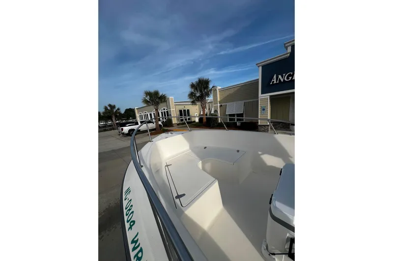 Slide: The Image of Sea Pro 200 Family Fish boat docked near a building under a clear blue sky. - 11