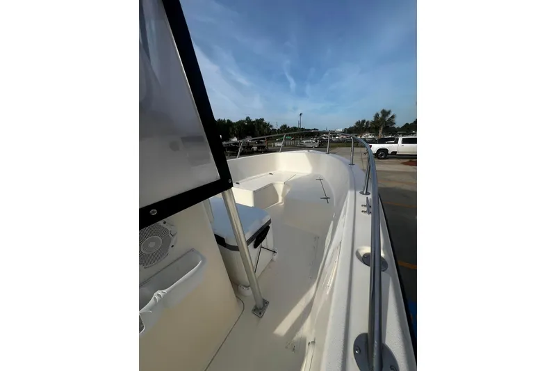 Slide: The Image of Sea Pro 200 Family Fish boat deck with clear sky and parked vehicles in background. - 9