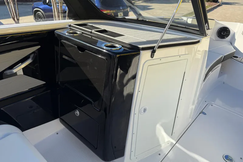 Slide: The Image of Interior view of 2026 Yamaha Boats 222SD, featuring sleek black and white cabinetry. - 18