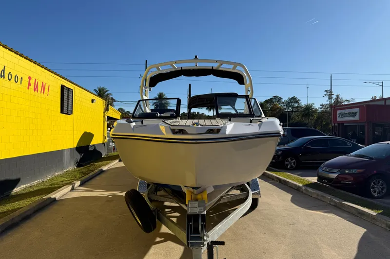 Slide: The Image of 2026 Yamaha Boats 222SD on trailer, parked outdoors under clear blue sky. - 4