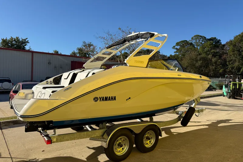 Slide: The Image of 2026 Yamaha Boats 222SD in yellow on a trailer, parked outdoors. - 7