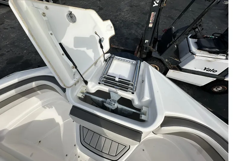 Slide: The Image of Open storage compartment on 2017 Yamaha Boats 242 Limited S, showing anchor and ladder. - 14