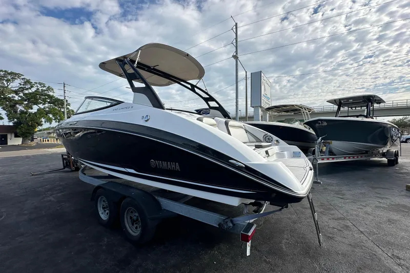 Slide: The Image of 2017 Yamaha Boats 242 Limited S on trailer under cloudy sky. - 2
