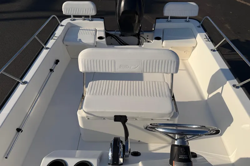 Slide: The Image of 2014 Boston Whaler 190 Montauk boat interior with white seating and steering wheel. - 12