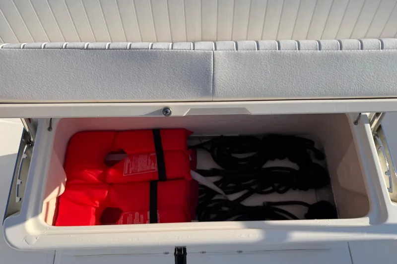 Slide: The Image of Open storage compartment on 2014 Boston Whaler 190 Montauk with life jackets and ropes. - 17