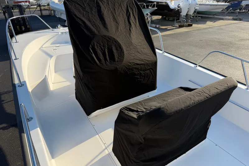 Slide: The Image of 2014 Boston Whaler 190 Montauk boat with covered seats, docked outdoors. - 19