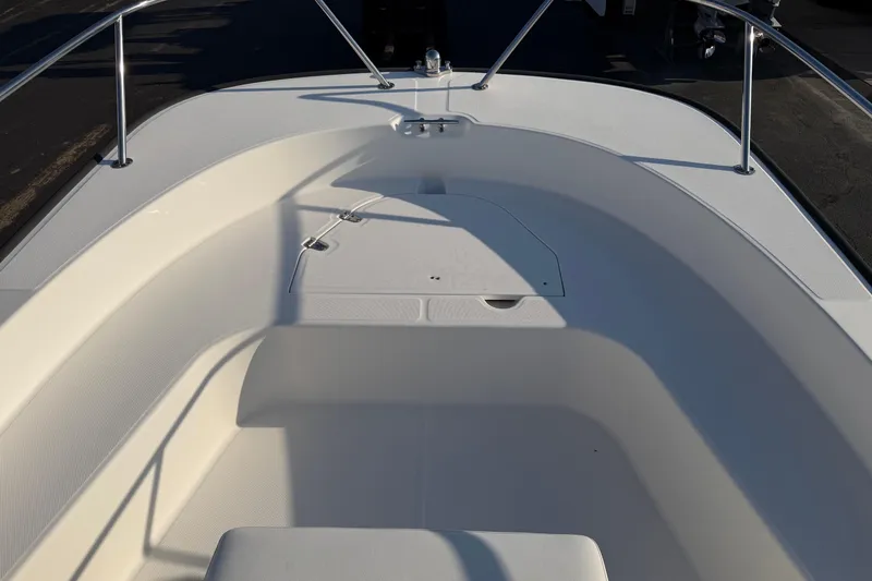 Slide: The Image of 2014 Boston Whaler 190 Montauk boat interior with white seating and stainless steel railings. - 5